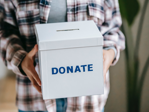 a person holding a box that says donate